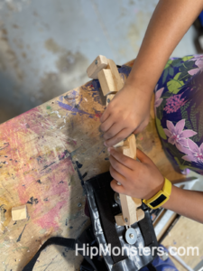 A cosplay, wooden, flexible tail being assembled.