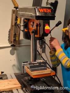 Using a drill press to create a wooden toy alligator